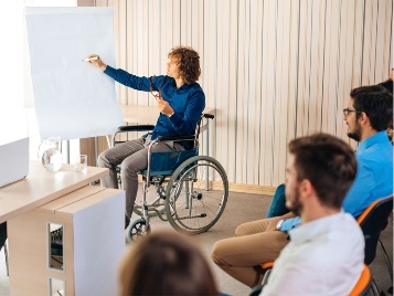 A person in a wheelchair teaching a group of people.