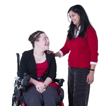 A woman placing her hand on the shoulder of a woman in a wheelchair in a supportive way. 