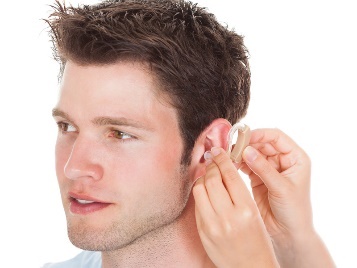 A person having a hearing aid fitted to their ear.